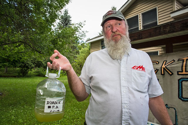 Ray Kemble, a former industry worker in Dimock, PA, holds up water taken from his contaminated well. (Photo: ©2015 Julie Dermansky)
