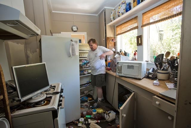 Walter Unglaub returns to flooded home and empties the refrigerator. (Photo: © 2016 Julie Dermansky)