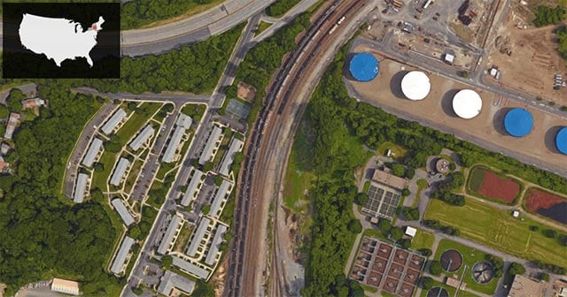 Ezra Prentice Homes is the complex of grey-roofed buildings bordering the left side of the train tracks—where a line of tanker cars can be seen lined up. Global's facility and storage tanks are on the opposite side of the rail tracks. (Imagery: © 2016 Google / Map data: © 2016 Google)