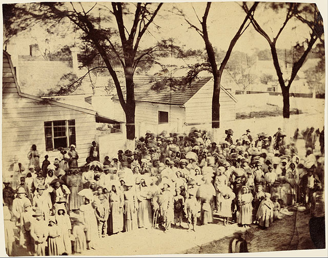Slaves on J.J. Smith's cotton plantation near Beaufort, South Carolina, standing before their quarters in 1862.