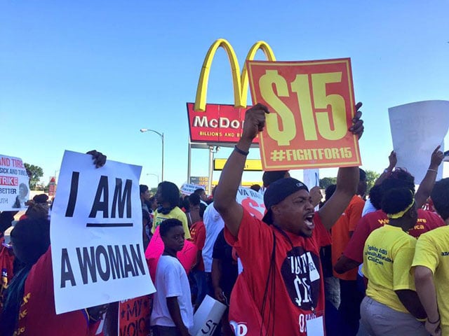 Activists chant and display signs at a 2016 Fight for $15 action. (Photo: Fight for $15)