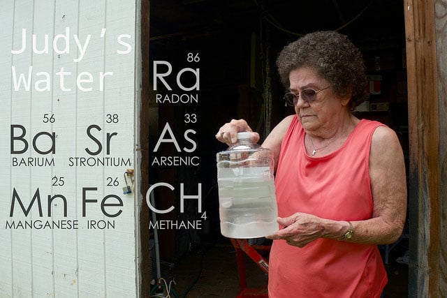 Judy Eckert holding water contaminated with arsenic drawn from her private well 450ft from a fracking rig in Pennsylvania, which she believes contaminated her water supply.