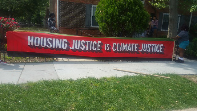 Housing Justice is Climate Justice banner in front of James Creek residents council office. (Photo: Kari Fulton)