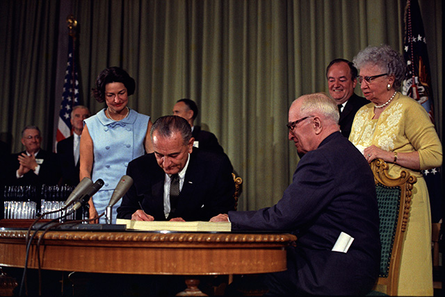 President Lyndon B. Johnson signs the Medicare Bill at the Harry S. Truman Library in Independence, Missouri, July 30, 1965. (Photo: Executive Office of the President of the United States)