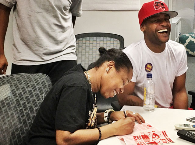 Shantel Walker, a Papa John’s employee and leader of the Fight for $15, signs a card to join Fast Food Justice, a new labor organization in New York City. (Photo: WNV / Fast Food Justice)