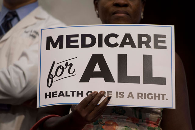 A member of the audience holds up a placard as US Senator Bernie Sanders, Independent from Vermont, discusses Medicare for All legislation on Capitol Hill in Washington, DC, on September 13, 2017. (Photo: Jim Watson / AFP / Getty Images)