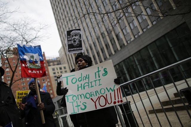 People take part in a protest against U.S. President Donald Trump's recent statements and words about immigration in front of the Federal Building on January 19, 2018 in New York. U.S. President Trump balked at an immigration deal that would include protections for people from Haiti and some nations in Africa, demanding to know on a meeting why he should accept immigrants from 