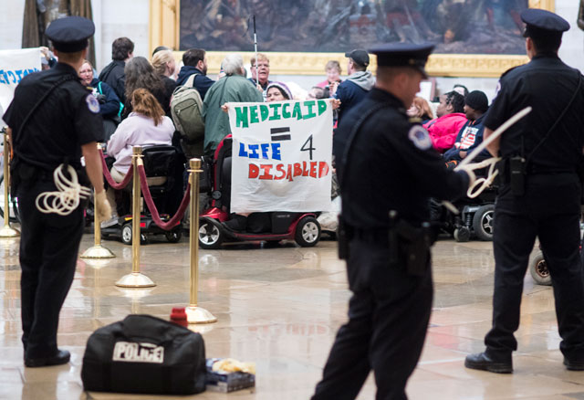 US Capitol police prepare flex cuffs to arrest members of ADAPT protesting in the Capitol rotunda against the American Health Care Act of 2017 and cuts to Medicaid on Wednesday, March 22, 2017. (Photo: Bill Clark / CQ Roll Call)