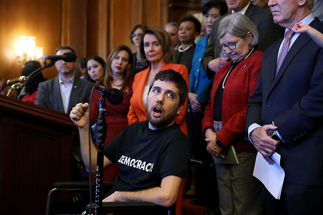 Ady Barkan delivers remarks during a rally organized by House Minority Leader Nancy Pelosi in the Rayburn Room at the US Capitol on December 19, 2017, in Washington, DC. (Photo: Chip Somodevilla / Getty Images)