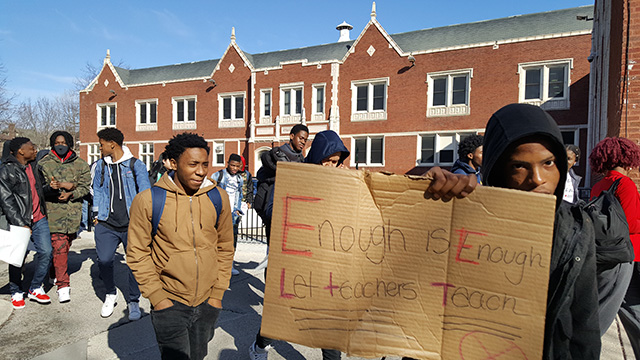 A student at Sullivan High School in Chicago carries a sign that reads, 