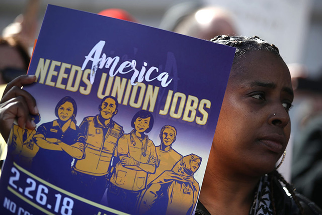 A union member holds a sign during a rally outside of San Francisco City Hall on February 26, 2018, in San Francisco, California. (Photo: Justin Sullivan / Getty Images)